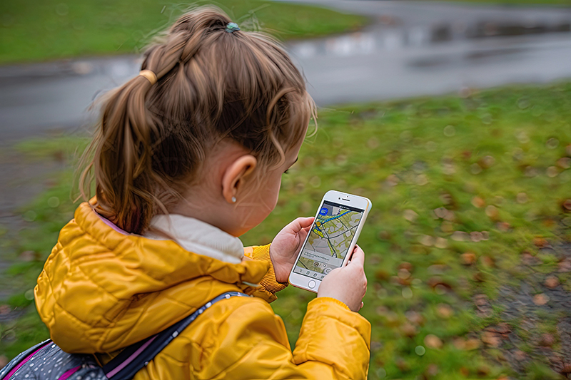 a little girl looking at a map on her phone